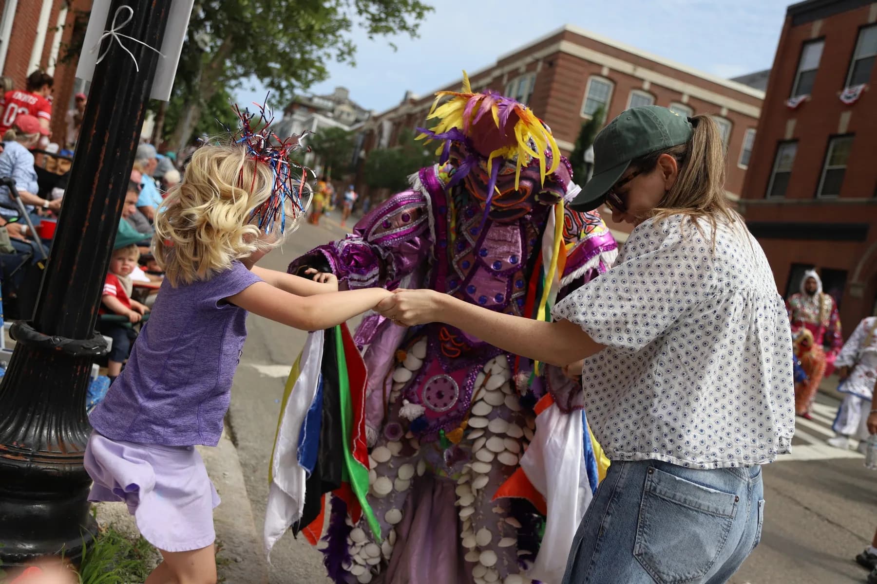 A family joins hands with a Carnaval performer as the parade brings generations together