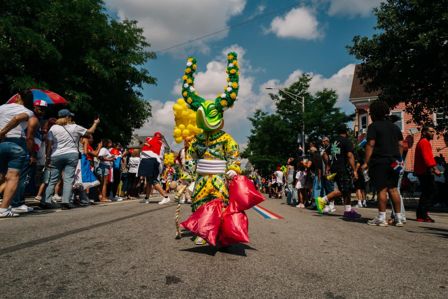 A costumed ACM performer dances in the street during the 2026 Providence parade