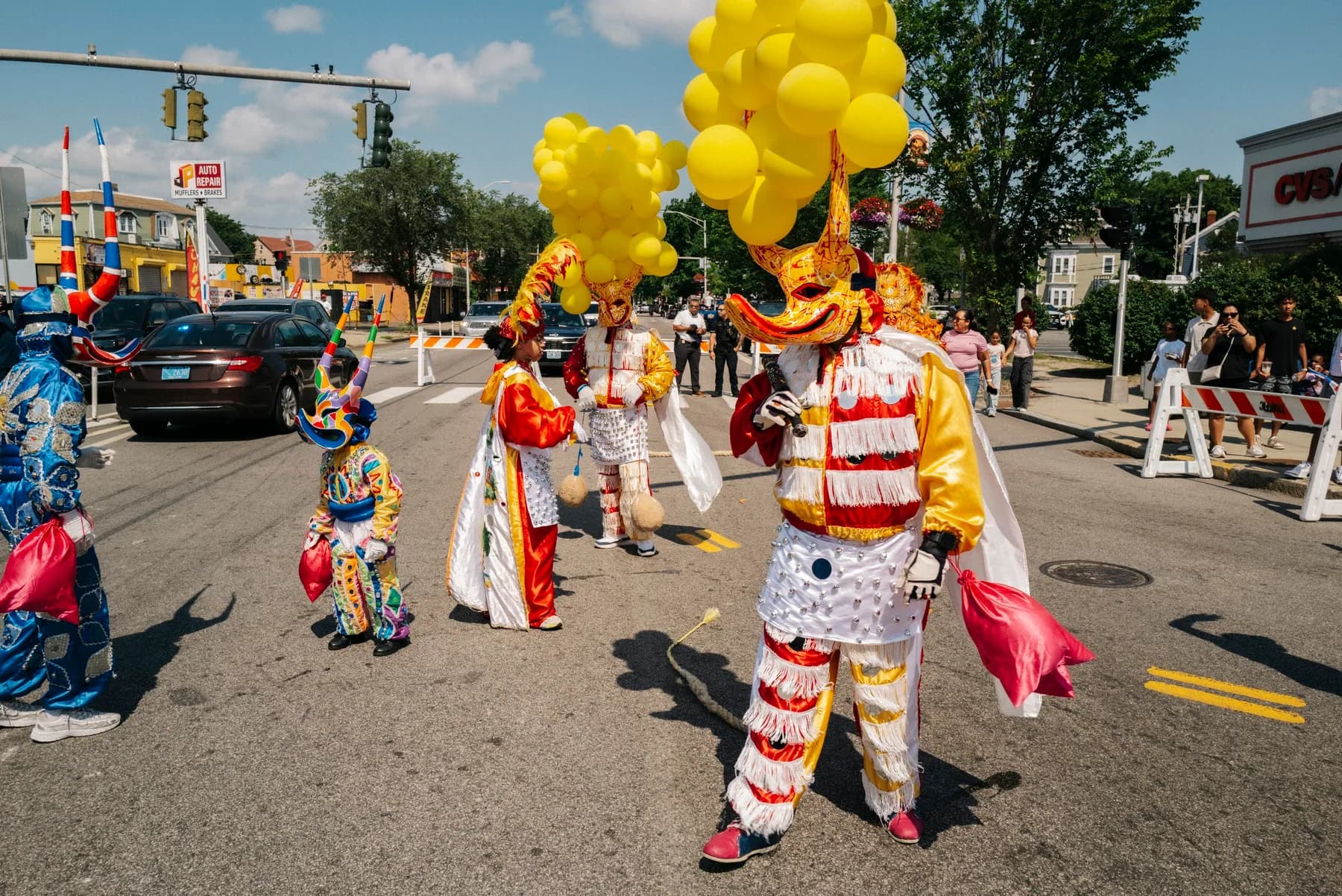 ACM performers move down the Providence parade route beneath yellow balloons and Dominican flags