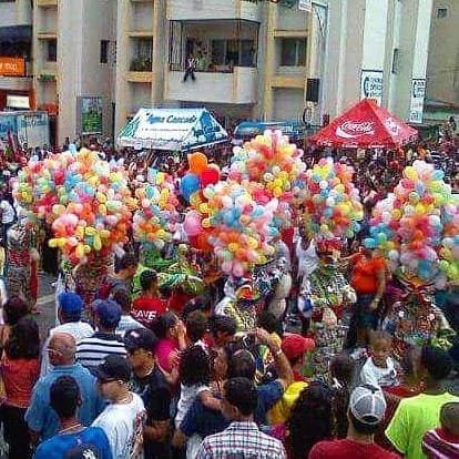 A large crowd gathered around ACM performers during a Dominican Carnaval celebration