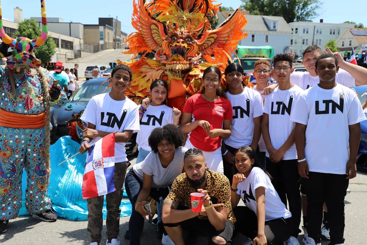 Young ACM performers and families celebrating Dominican heritage along a parade route