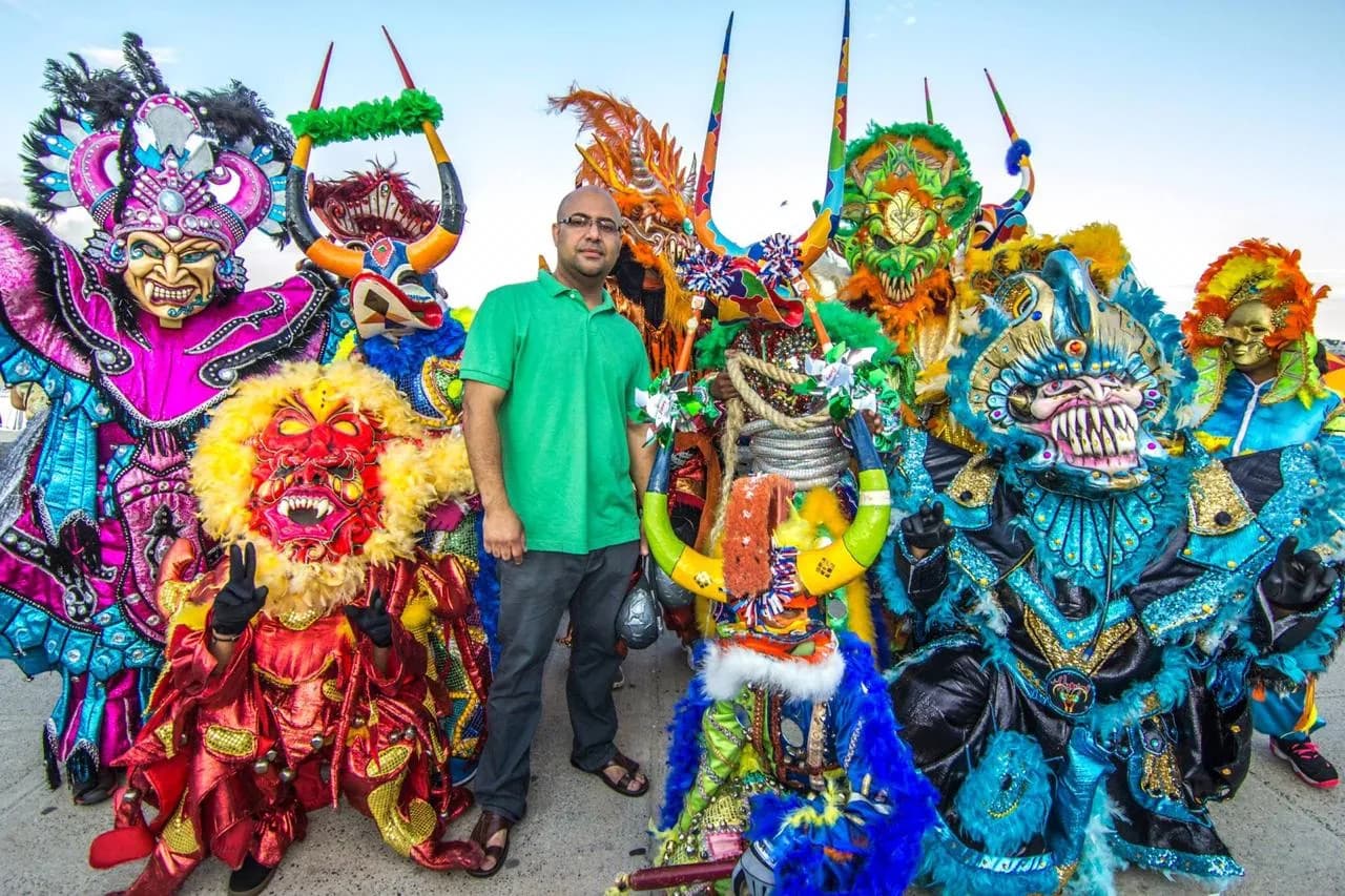 Mirabal family members gathered with ACM performers in handcrafted Carnaval masks and suits